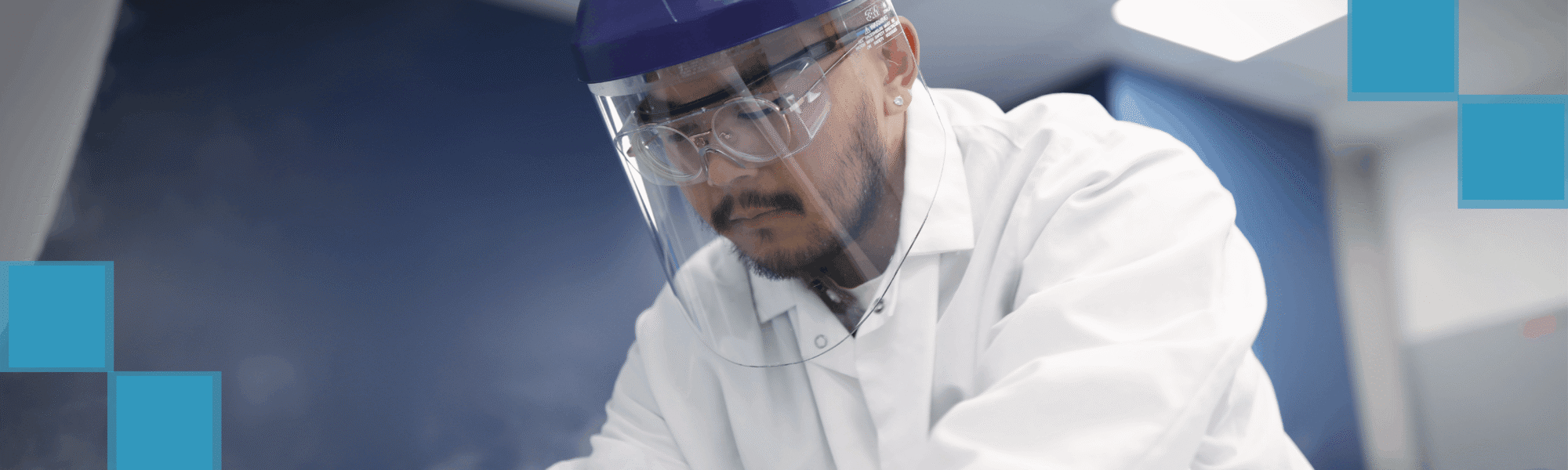 Worker wearing a face shield and safety goggles with decorative teal squares overlay