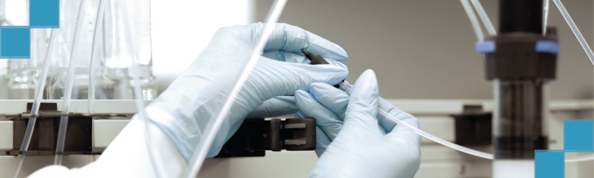 Gloved hands adjusting tubing on lab equipment with teal decorative squares overlay
