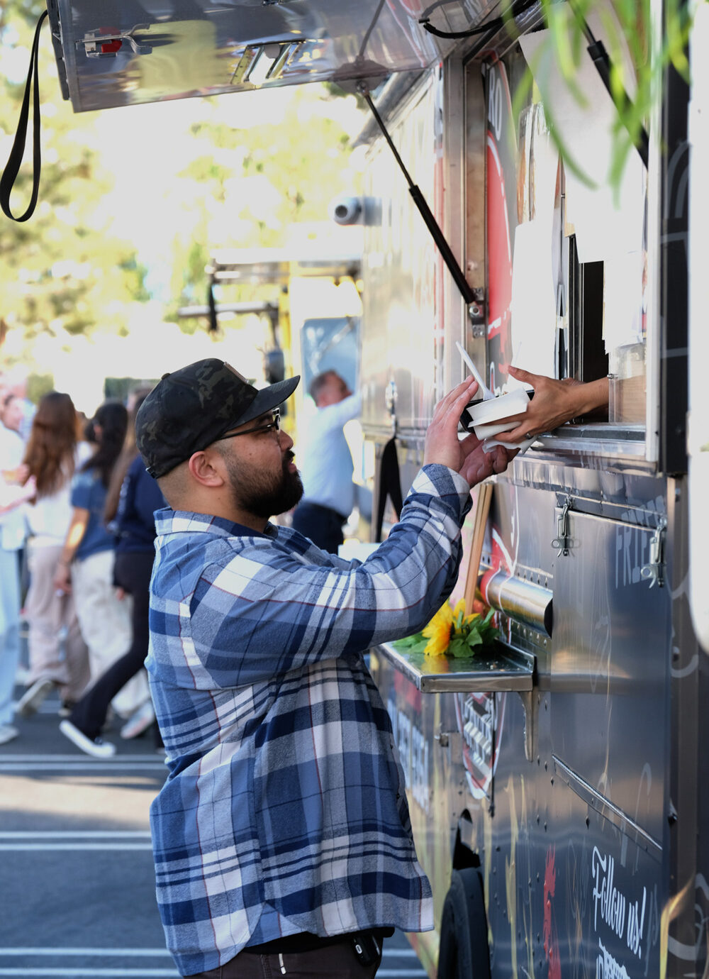 Close-up of a food truck serving window at an outdoor company event