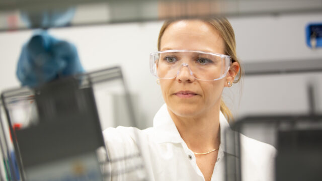 Close-up of a female lab worker wearing safety goggles in a laboratory