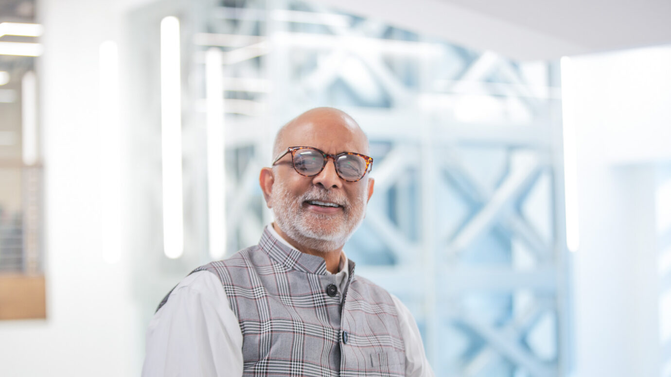 Smiling older man with a beard and glasses in an office setting