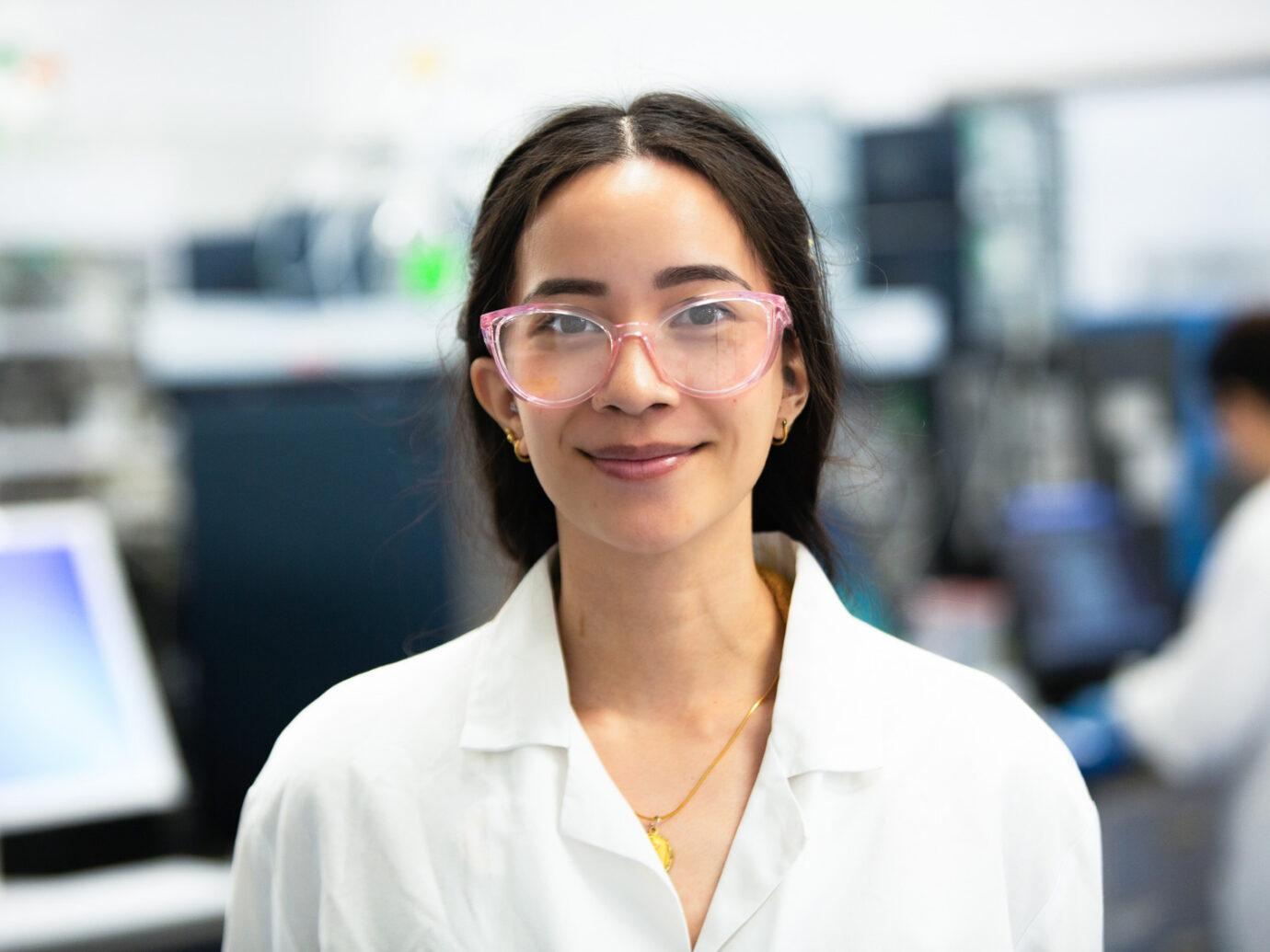 Smiling woman wearing pink glasses, close-up office portrait