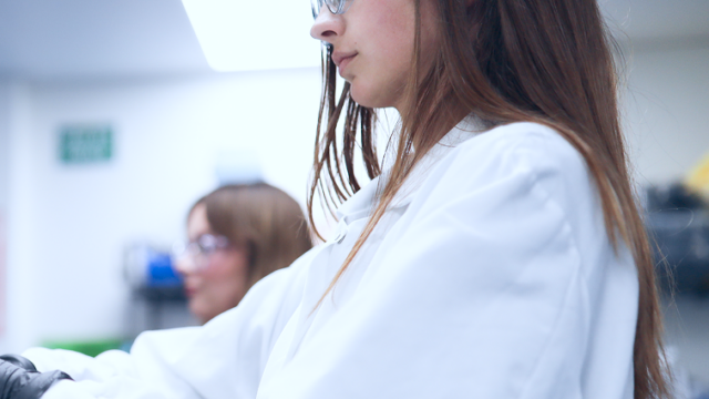 Profile view of a woman wearing glasses working at a laptop