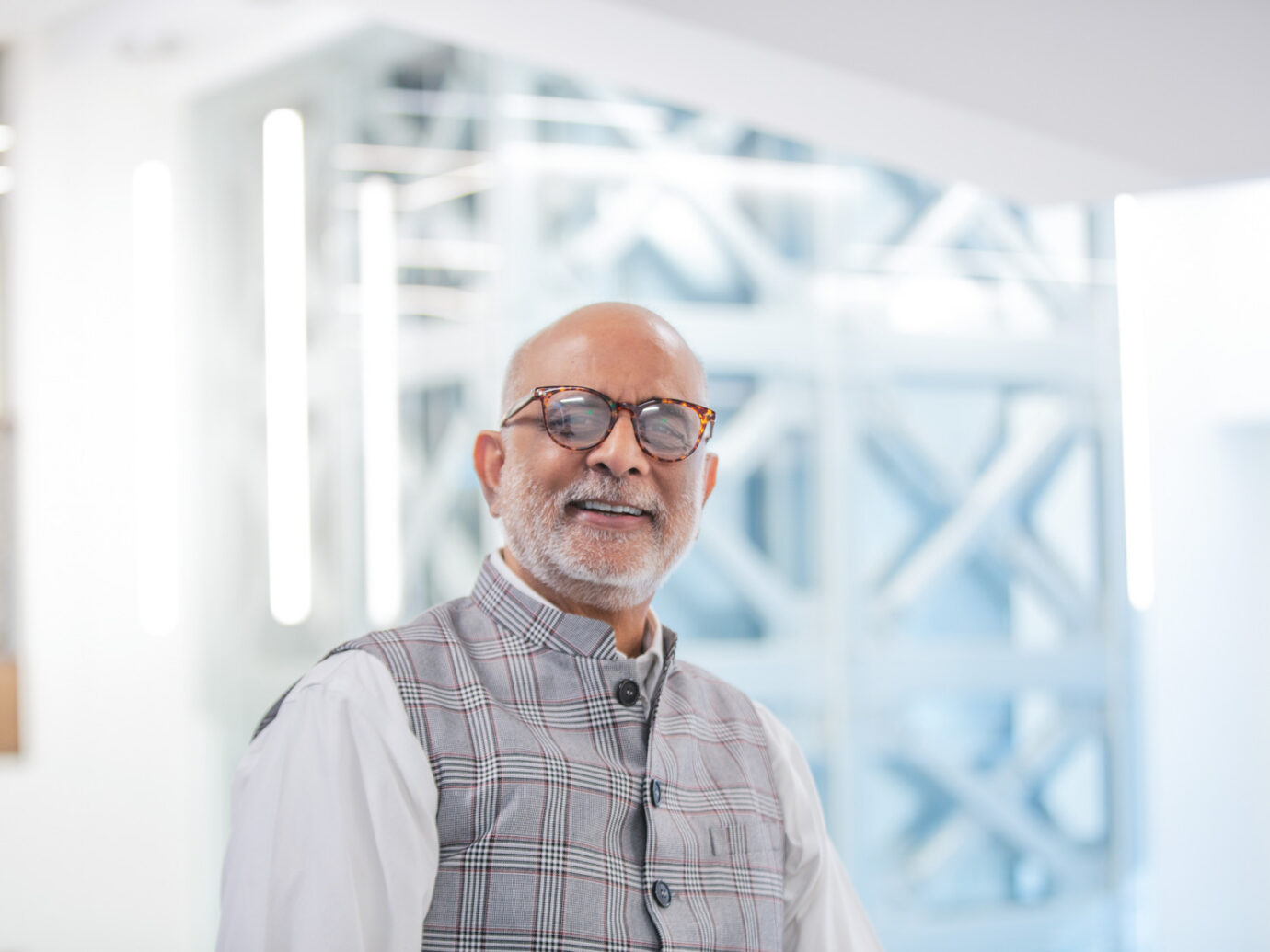 Smiling older man with a beard and glasses in an office setting
