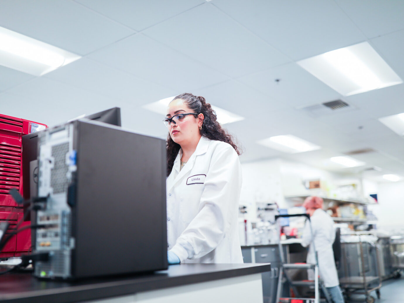 Profile view of a woman wearing safety glasses in a lab