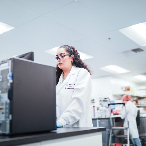 Female scientist wearing glasses and a lab coat working in a laboratory