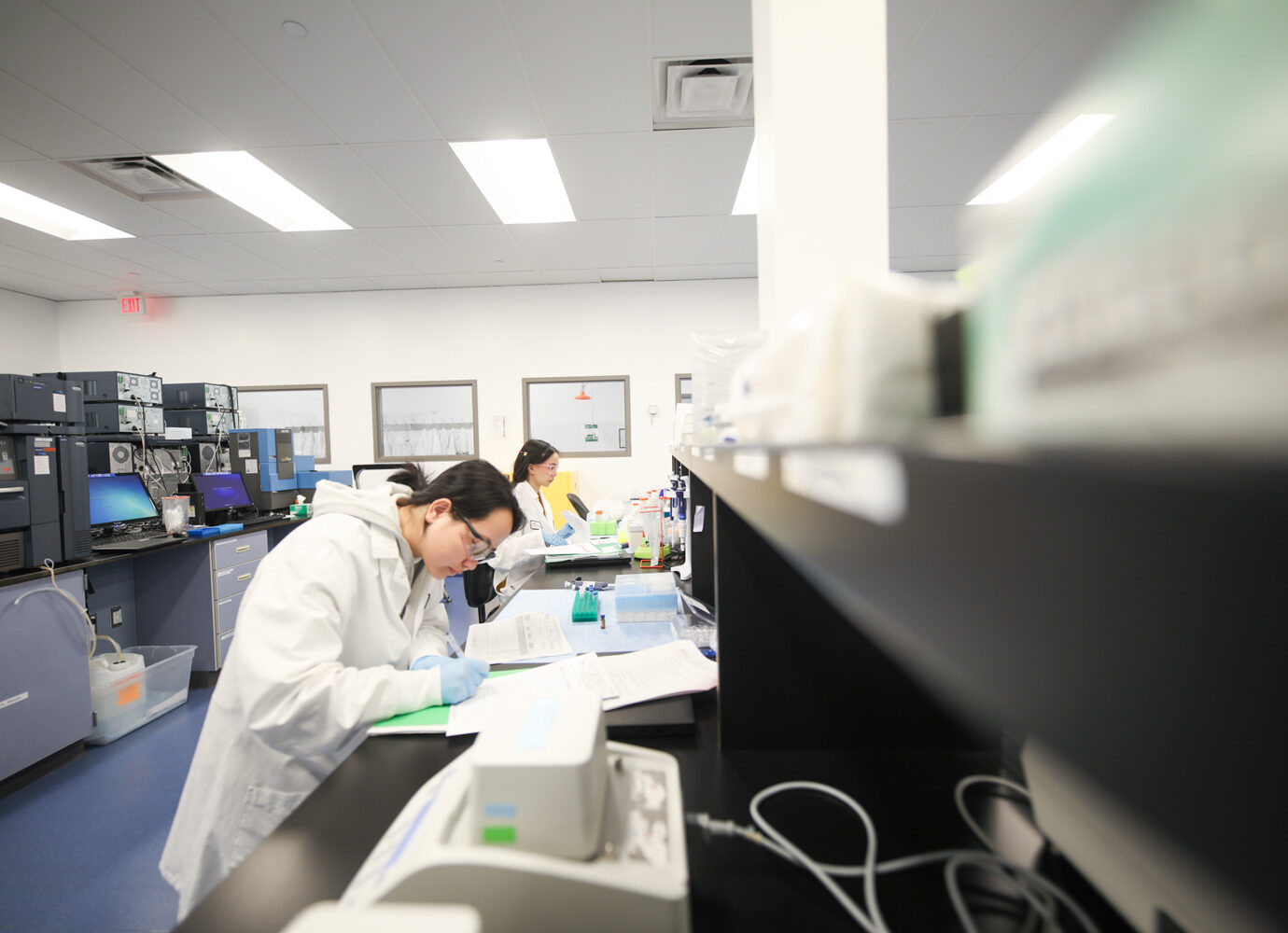 Wide view of a laboratory with instrument benches and scientists working