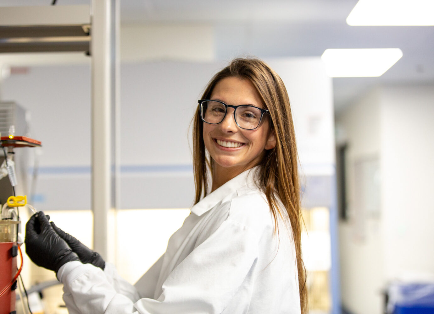 Smiling woman wearing glasses in a facility