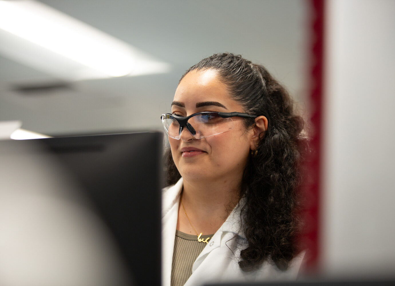 Woman wearing glasses in an office hallway