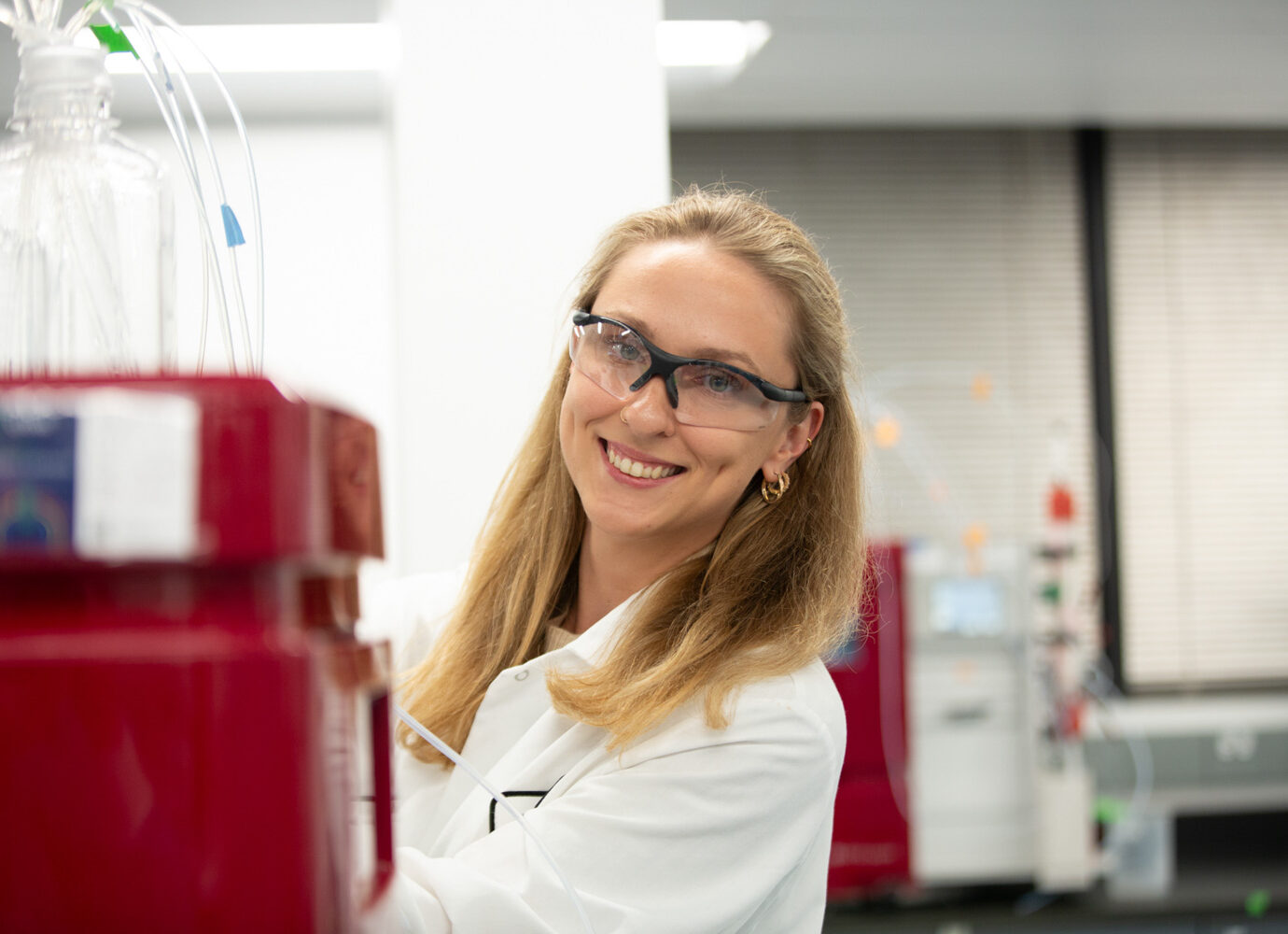 Smiling female scientist wearing safety glasses in a laboratory
